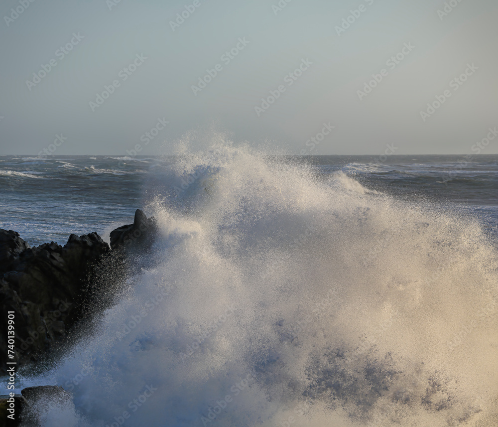 Small cape being hit by strong stormy sea waves