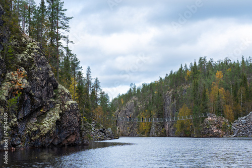 Canyon lake called Julma   lkky with a small suspension bridge on an autumn day in Hossa National Park  Northern Finland 