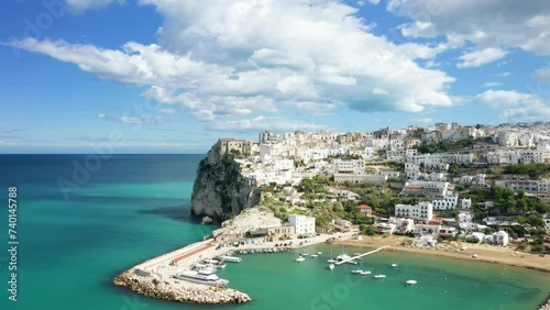 The city center, the port and the beach of Peschici in Europe, In Italy, in Puglia, towards Foggia, in summer, on a sunny day. photo