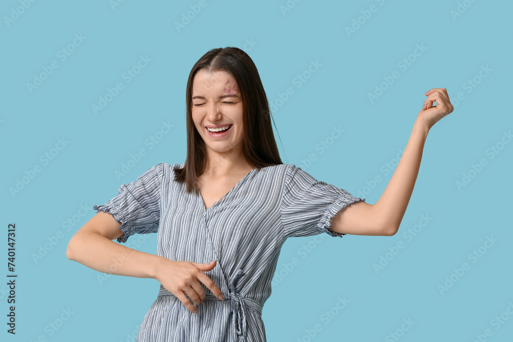 Pretty young woman playing imaginary guitar on blue background Pretty young woman playing imaginary guitar on blue background