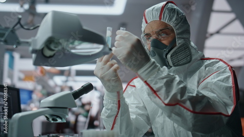 Chemistry expert researching virus in protective uniform at laboratory close up photo