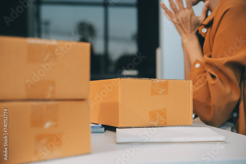 businesswoman start small business and successful SME entrepreneurs asian woman hoding boxs works from home delivering parcels online. SME delivery concept and packaging photo