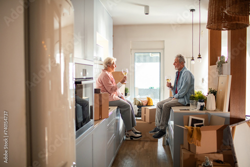 Senior couple drinking wine after moving in photo