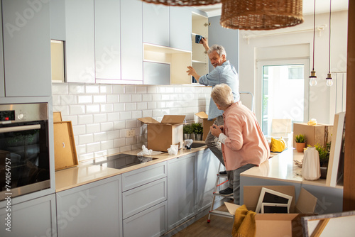 Senior couple unpacking items in new home photo