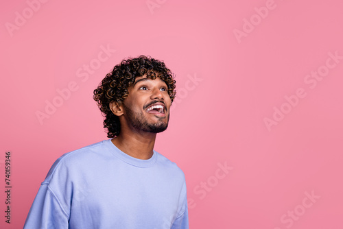 Photo of positive man wear blue stylish clothes watch billboard information promo ad empty space isolated on pink color background © deagreez