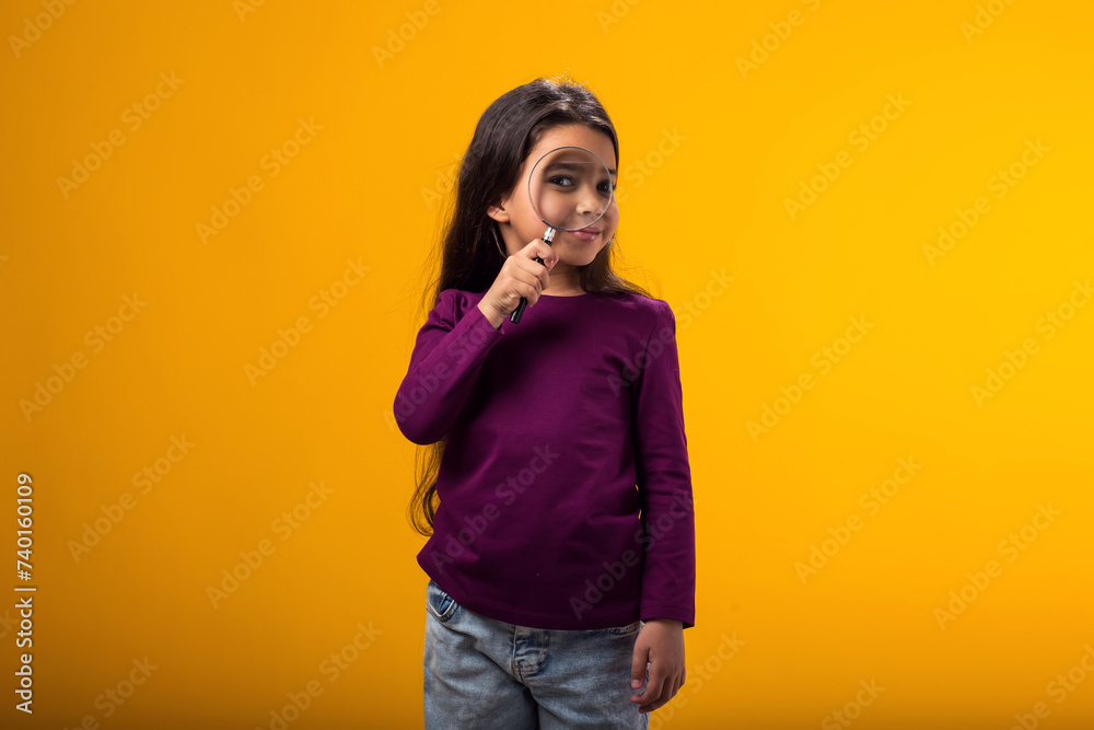 Smiling kid girl holding magnifier in hand. Education and curiosity concept Smiling kid girl holding magnifier in hand. Education and curiosity concept