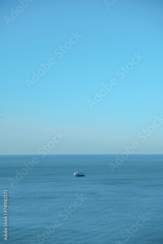 ship goes into the horizon of the blue sea, leaving a trail on the surface of the water landscape. Aerial view, concept of sea travel, cruises