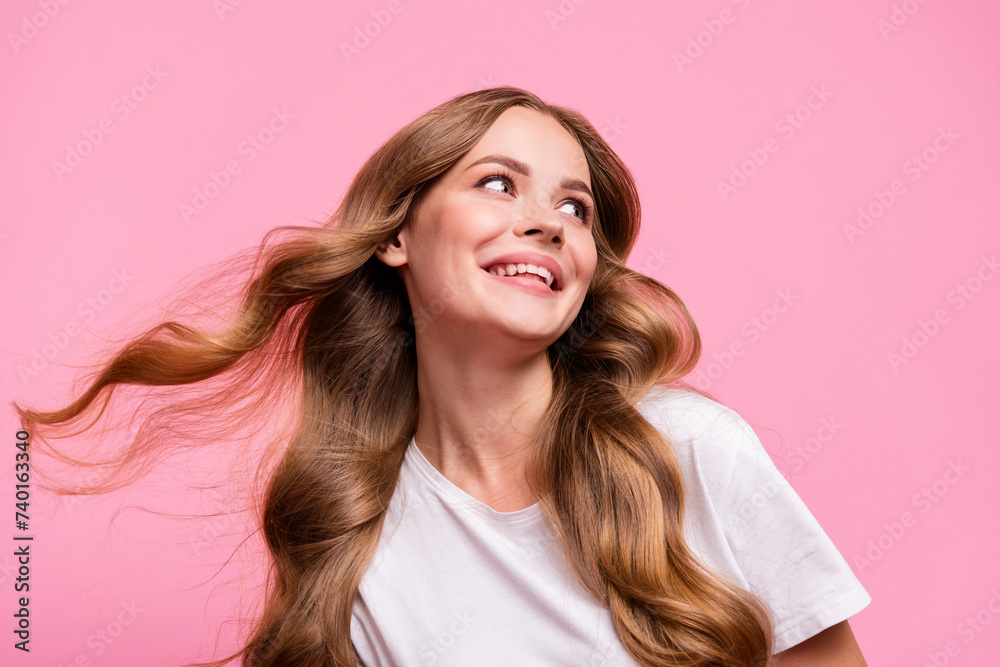 Photo of nice cute woman with wavy fluttering hairstyle dressed stylish t-shirt look at sale empty space isolated on pink color background Photo of nice cute woman with wavy fluttering hairstyle dressed stylish t-shirt look at sale empty space isolated on pink color background