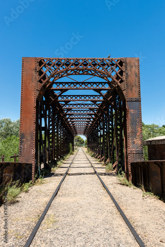 man walking on an old iron bridge over the train tracks  © Alejandro Piorun
