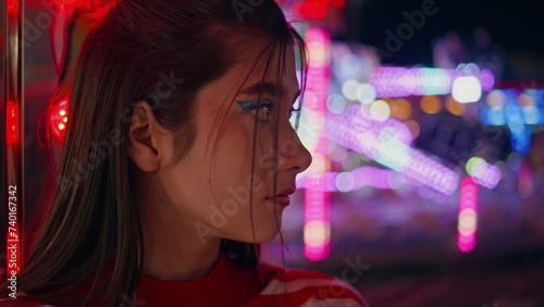 Attractive girl rest funfair closeup. Unhappy sad woman at neon amusement park