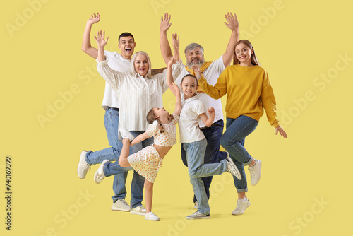 Big family jumping on yello...