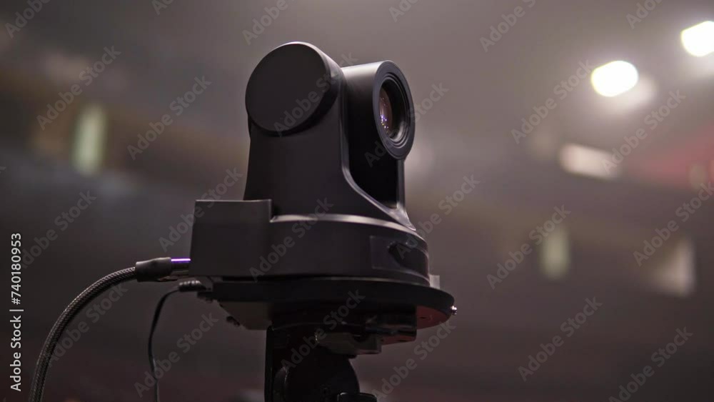  A robotic camera captures images at a concert, where bright lights and visual effects create a futuristic and exciting atmosphere concert concept button, television, production, video, broadcasting