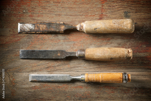 Three disused wood chisels on a wood table