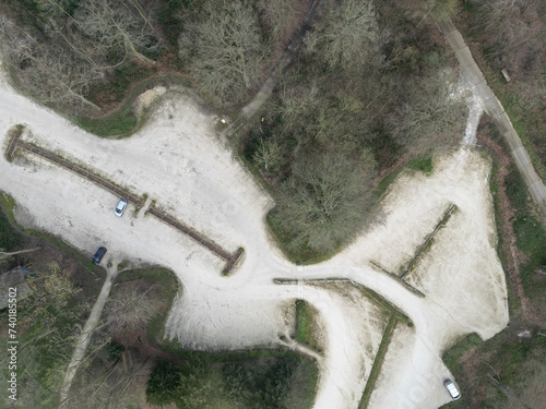 Aerial view of a nearly empty country car park seen in late winter. Dense woodland can be seen surrounding the car park, seen near Sherwood Forest in the UK. photo