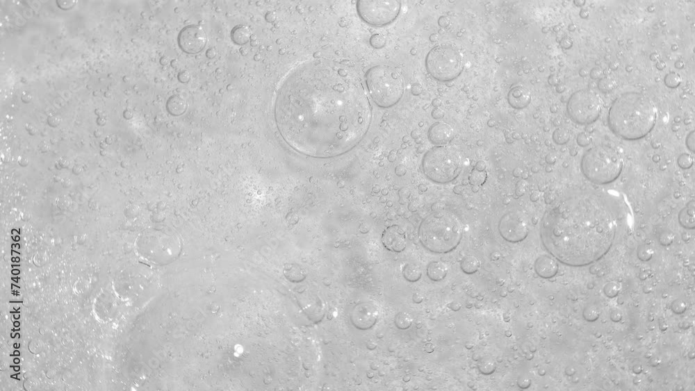 Texture of transparent cosmetic gel with bubbles, the texture of serum. Movement, rotation of sample of cosmetic skin care product