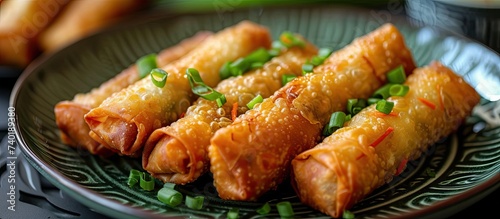 A plate of chicken egg rolls made with minced chicken, tapioca, carrots, scallions, and eggs, sitting on a table.