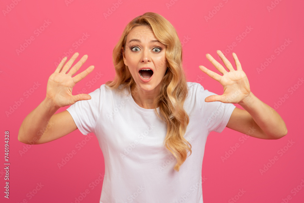 Portrait of emotional blonde woman looks at camera raising hands Portrait of emotional blonde woman looks at camera raising hands