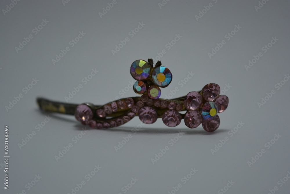 Beautiful women's jewelry and elegant costume jewelry. Women's stylish metal hair clip with large pink stones placed on white background. Beautiful women's jewelry and elegant costume jewelry. Women's stylish metal hair clip with large pink stones placed on white background.