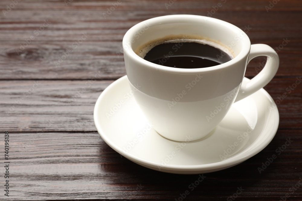 Cup of aromatic coffee on wooden table, closeup. Space for text