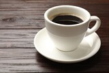 Cup of aromatic coffee on wooden table, closeup. Space for text