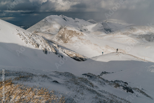 Beautiful winter mountain landscape of Hochschwab. Winter mountains and hikers on an adventure ascent in austrian Alps. Winter alpine landscape.