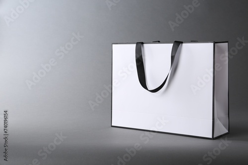 One paper bag on grey background, space for text. Mockup for design