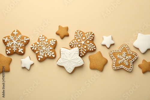 Tasty Christmas cookies with icing on beige background, flat lay