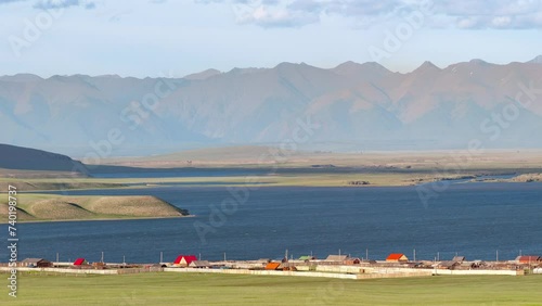 Tsagaannuur village, lake, mountains and green steppe, Khovsgol province, Mongolia, elevated view under golden light, late afternoon photo