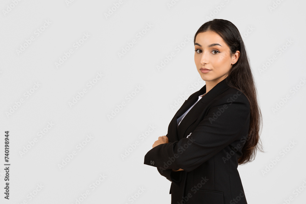 Confident businesswoman in black suit standing with arms crossed Confident businesswoman in black suit standing with arms crossed