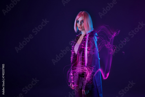 Woman in futuristic costume. Female in modern VR glasses interacting with network while having virtual reality experience. Augmented reality game, future technology, AI concept. VR. Neon purple light.