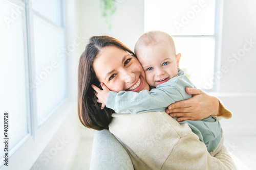 Happy young mother enjoying time with her adorable toddler son at home