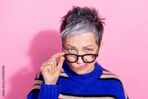 Portrait of strict funny woman wear striped pullover fingers touch glasses suspiciously look at you isolated on pink color background