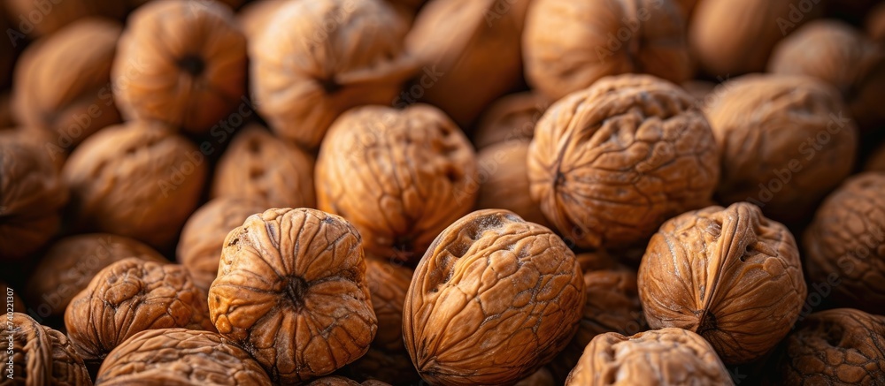 In this photo, a pile of walnuts has been peeled, revealing the smooth and rich nut inside the cracked shells. In this photo, a pile of walnuts has been peeled, revealing the smooth and rich nut inside the cracked shells.