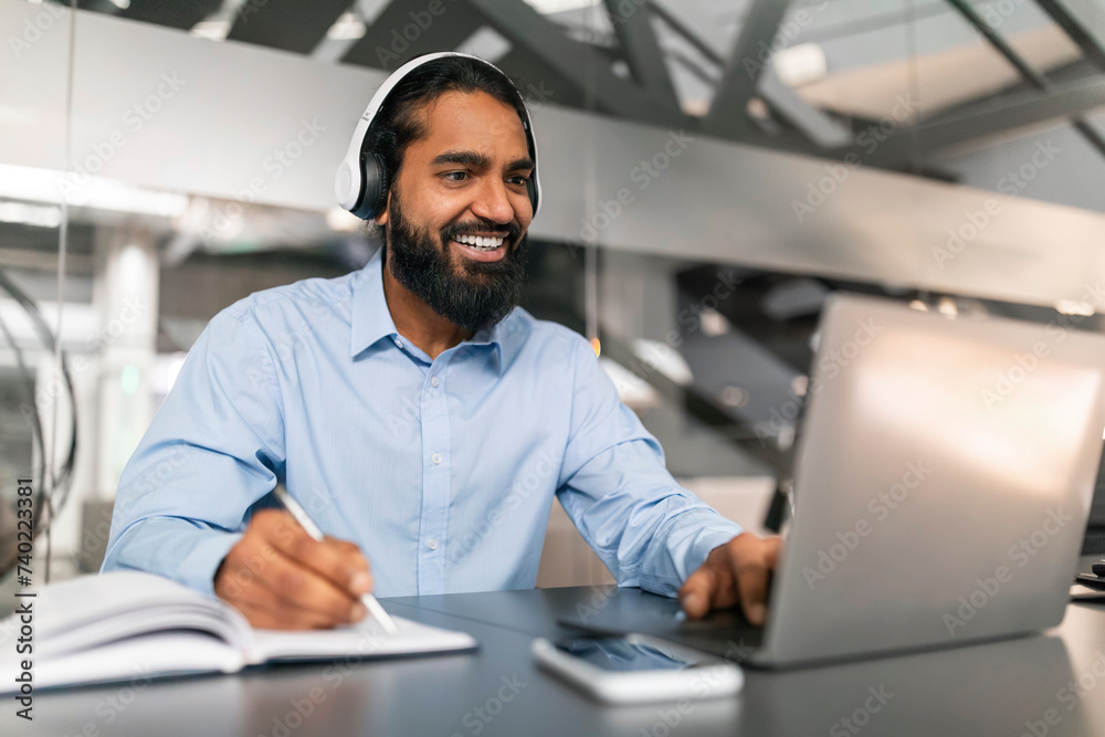 Young indian man having online training or attending webinar