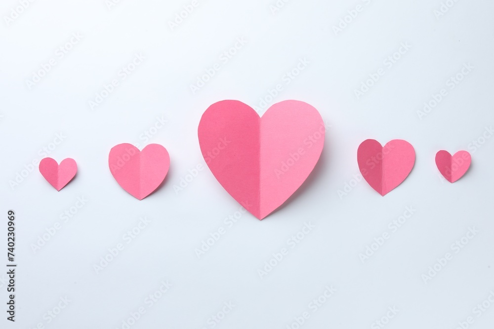 Pink paper hearts on white background, flat lay