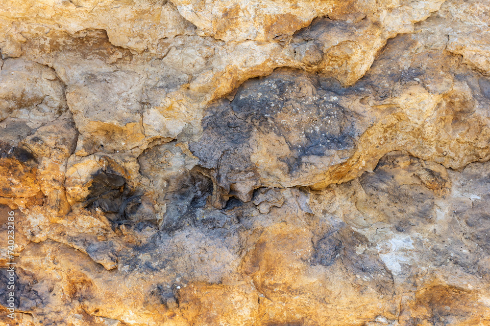 the wall of a mountain canyon made of natural material, limestone material of volcanic origin, close-up. the wall of a mountain canyon made of natural material, limestone material of volcanic origin, close-up.