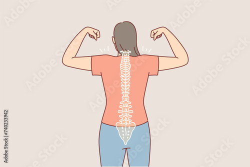 Woman with good posture and straight spine shows biceps, standing with back to camera