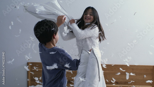 Happy Siblings in Fun Pillow Fight, Feathers Flying, Super Slow Motion Capture