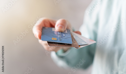 Woman holding credit and debit cards, choosing which to use (all Identifying information removed, altered)