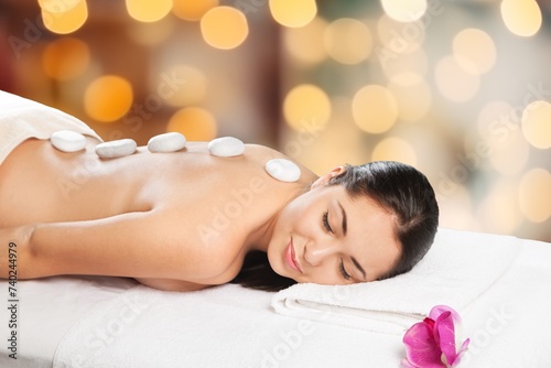 Woman enjoying body massage at spa salon.