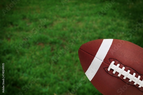 Classic American football ball at green grass