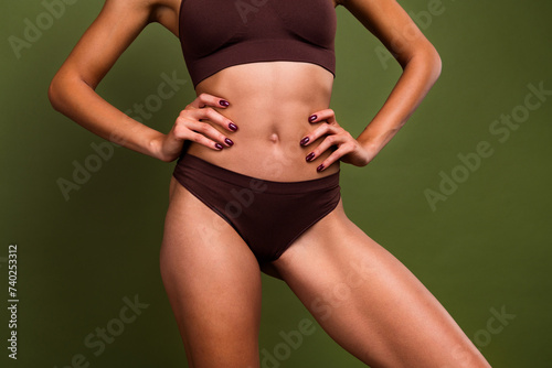 Cropped no filter photo of slim sporty perfect strong girl with ideal athletics shape isolated on khaki color background