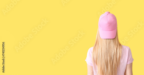 Photography Beautiful young woman in stylish baseball cap on yellow background with space fo