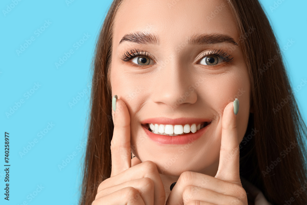 Smiling young woman with healthy teeth on blue background, closeup Smiling young woman with healthy teeth on blue background, closeup