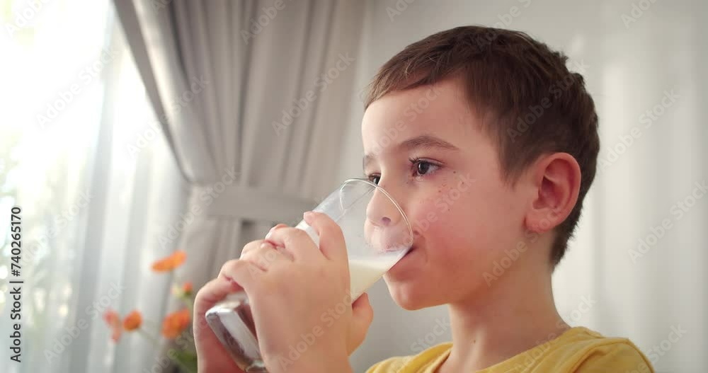 Cute Handsome child drinking milk.Healthy eating a child eating breakfast kid dream concept. Funny little boy in kitchen drinks yogurt milk and licks her lips.Positive kid smiling having breakfast. 4K Cute Handsome child drinking milk.Healthy eating a child eating breakfast kid dream concept. Funny little boy in kitchen drinks yogurt milk and licks her lips.Positive kid smiling having breakfast. 4K
