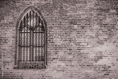 Fototapeta Naklejka Na Ścianę i Meble -  Okno z witrażem po lewej osadzone w ceglanej ścianie w czerni i bieli
