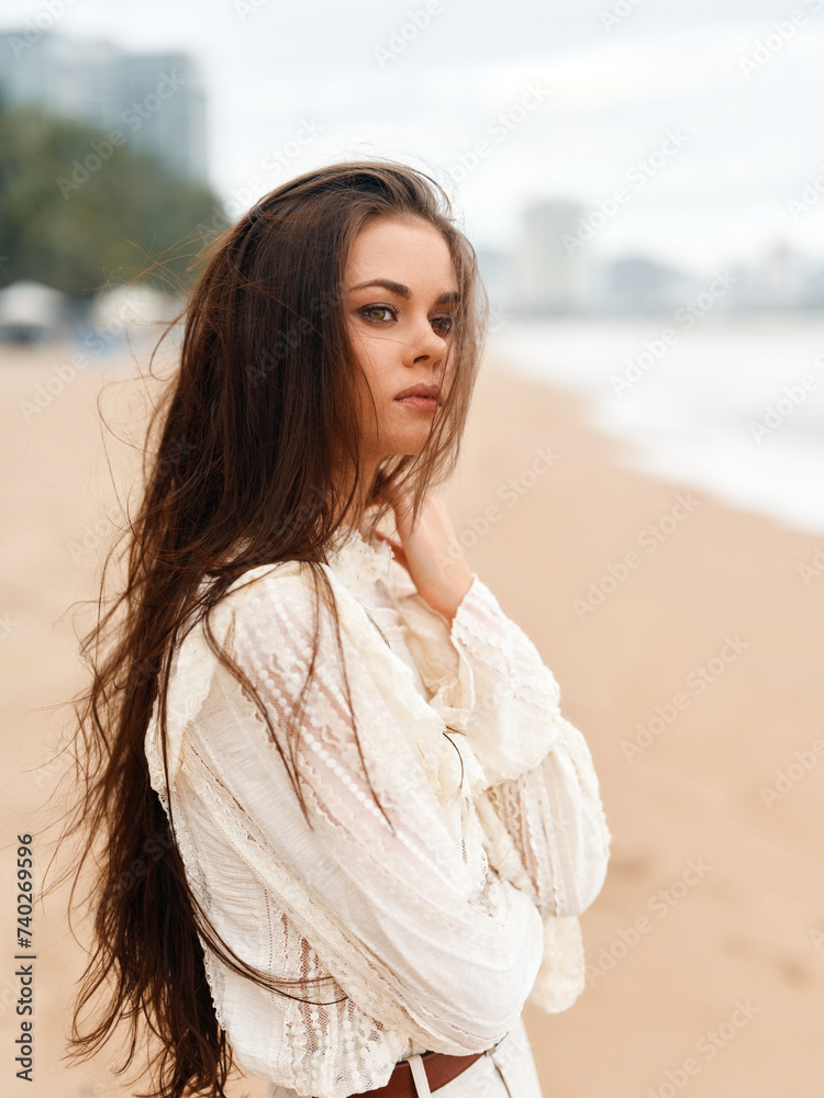 Stylish Caucasian Woman, Alone on the Beach, Posing with Calm Elegance and Gorgeous Red Hair, Embracing the Summer Light and Sensuality in a Fashionable Nature Background