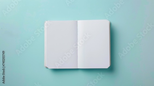 An open book with blank pages is placed on a blue background. The book is the main focus of the image. Mockup with copy-space, place for text, top view, flat lay.