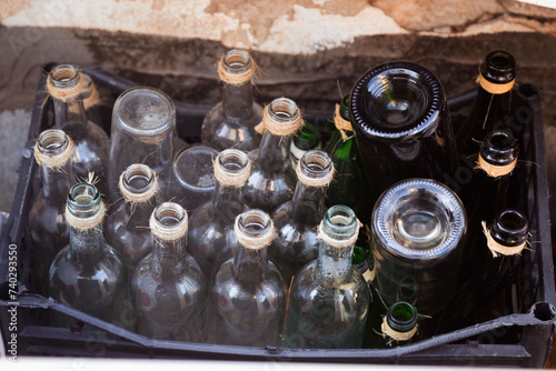 Assorted empty glass bottles with twine, in a crate, for eco recycling themes, perfect for travel and lifestyle media photo