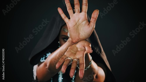 Closeup portrait fantasy african american woman voodoo witch conjuring ritual traditional. Art dance hands. Girl goth vampire dances hypnotizes sexy finger slow motion. mystical face. Black dress hood photo